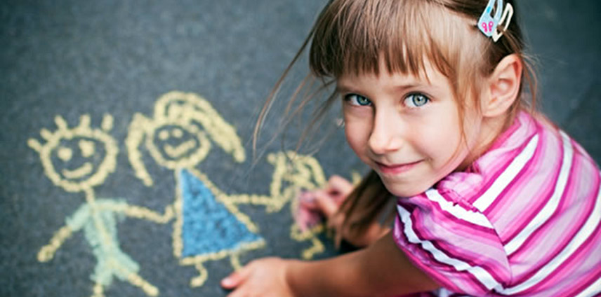 Девочка рисует мелом на асфальте