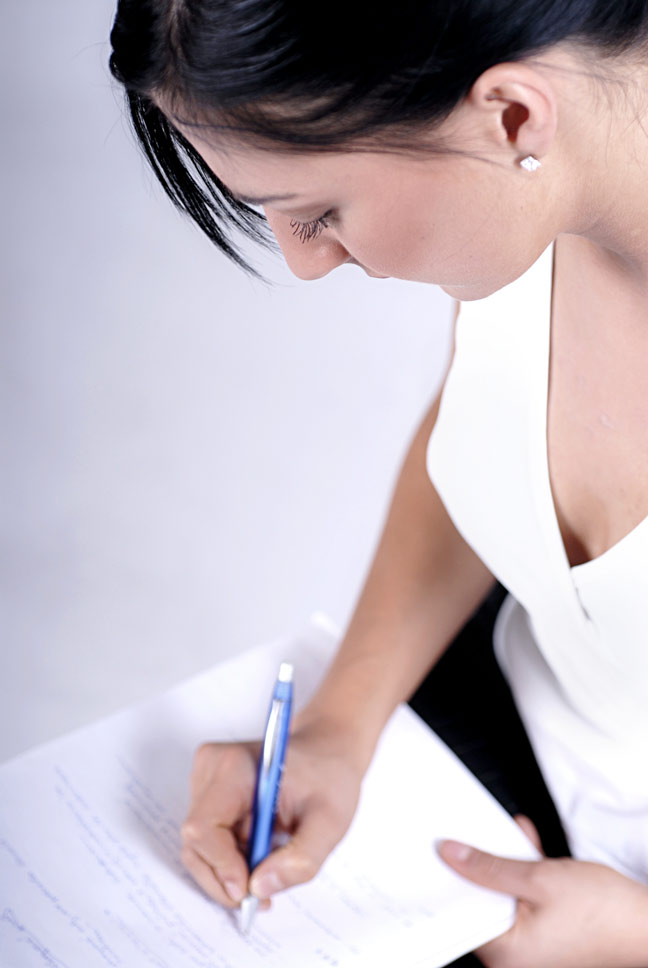Девушка, пишущая синей ручкой